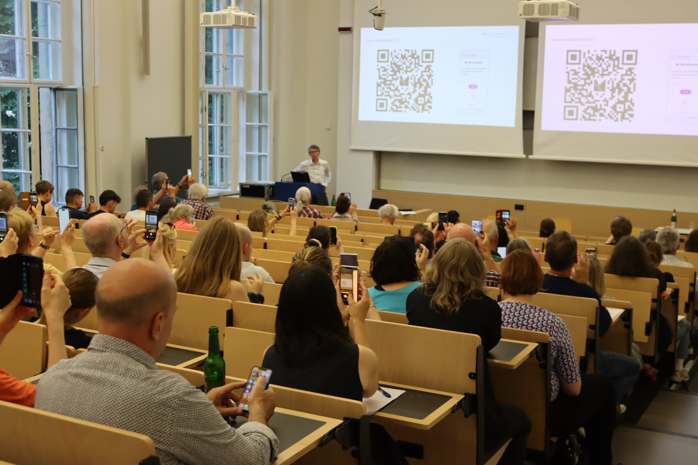 Frank Berner steht gestikulierend am Rednerpult im Hörsaal.
